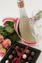 Bunch of roses, champagne bottle, wine glasses and assorted chocolate box Royalty Free Stock Photo