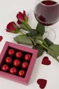 Bunch of roses, wine glass and assorted chocolate box Royalty Free Stock Photo