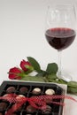 Bunch of roses, wine glass and assorted chocolate box Royalty Free Stock Photo