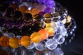 Bunch of semiprecious gemstone bracelets on black background - cornelian, amethyst, quartz