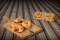 Bunch Of Sesame Puff Pastry On Old Cutting Board And Integral Brown Bread Loaf Set On Rustic Bamboo Place Mat