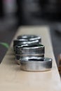 Bunch of silver ashtrays placed on wooden support