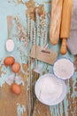 Bunch of spikelets of wheat, baguette and bakery ingredients on old wooden background. Text Homemade