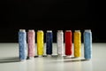 A bunch of spools of colored thread lined up for sacrifice