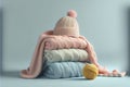 Bunch of stacked knitted pastel color sweaters scarf and hat with different knitting patterns folded on light background. Royalty Free Stock Photo