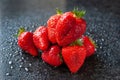 Bunch of strawberries. Wet ripe strawberries on a black background. Red berries with drops of water. Selective focus Royalty Free Stock Photo