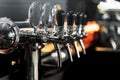 a bunch of taps are lined up in a bar with oranges and oranges