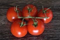 A bunch of tomatoes with a branch lying on a dark cutting board Royalty Free Stock Photo