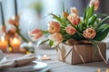 Bunch of tulips with gift box lying on set table ready for dinner. Royalty Free Stock Photo