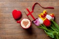 Bunch of tulips, heart, gift and a cup of coffee lying on the ta Royalty Free Stock Photo