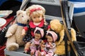 Dolls and teddies in a stroller at a flea market stall