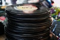 A bunch of vinyl records stacked in a flea market