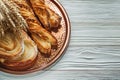 Bunch of wheat ears baked pastry brass tray on wooden background