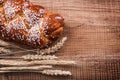 Bunch of wheat ears crusty roll on oak wooden Royalty Free Stock Photo