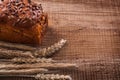 Bunch wheat ears loaf of bread on oak wooden board Royalty Free Stock Photo