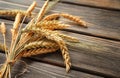 Bunch of wheat spikelets on wooden background