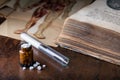 Bunch of white pills with glass ampoules and old medical book Royalty Free Stock Photo