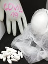 A bunch of white pills,medical cap,medical face masks,medical glove where written corona virus on a black and white background Royalty Free Stock Photo