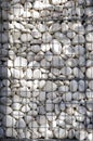 A bunch of white polished pebbles behind a metal grid