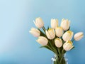 A bunch of white tulips in a glass vase celebrate Mothers day