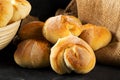 Bunch of whole, fresh baked wheat buns on dark wooden table Royalty Free Stock Photo