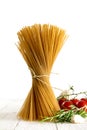 Bunch of wholemeal spaghetti standing on white wood with some to Royalty Free Stock Photo