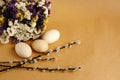 Bunch willow buds and flowers and wooden eggs on craft backgroun