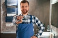 Bunch of wrenches in hand. Plumber in blue uniform is at work in the bathroom Royalty Free Stock Photo