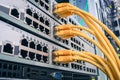 A bunch of yellow communication cables connect to the router interfaces. Telecommunication equipment is in the server room of the