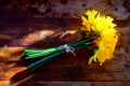 Bunch of yellow daffodils tied together with string laying on th