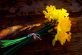 Bunch of yellow daffodils tied together with string laying on a
