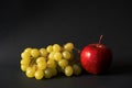 A bunch of yellow grapes and a red Apple on a black background Royalty Free Stock Photo