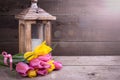 Bunch yellow and pink spring tulips and candle in lantern on v