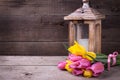 Bunch yellow and pink spring tulips and candle in lantern on v