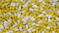 Bunch of yellow white capsule pills on a white background - Medicine healthcare medicaments