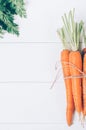 Bunch of young carrots with green tops on white wooden vintage table, healthy food on mock up background Royalty Free Stock Photo