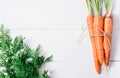 Bunch of young carrots with green tops on white wooden vintage table, healthy food on mock up background top view Royalty Free Stock Photo