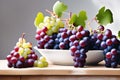 Ripe red grapes. Bunches of dark pink grapes with green leaves lie on a white plate. Fresh harvest Royalty Free Stock Photo