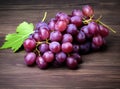 Bunches of fresh ripe red grapes on a wooden textural surface. Ancient style, a beautiful background with a branch of