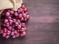 Bunches of fresh ripe red grapes on a wooden textural surface. Ancient style, a beautiful background with a branch of