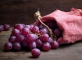 Bunches of fresh ripe red grapes on a wooden textural surface. Ancient style, a beautiful background with a branch of