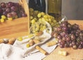Bunches of grapes, wineglass, bottles and corks on wooden background. Royalty Free Stock Photo