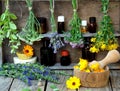 Bunches of healing herbs - mint, yarrow, lavender, clover, hyssop, milfoil, mortar with flowers of calendula and bottles, Royalty Free Stock Photo