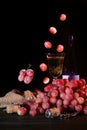 Bunches of pink grapes and green apples on a dark background. A glass of champagne is in the background. Still life. Vitamin Royalty Free Stock Photo