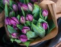 Bunches of purple tulip wrapped in craft paper for sale. Fresh spring lilac flowers. Colorful florist display. Royalty Free Stock Photo