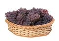 Bunches of red grape in wicker basket on isolated white background