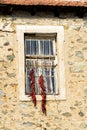 Bunches of red peppers dried in the sun hang in front of the window