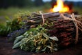 bunches of sacred herbs near a solstice bonfire