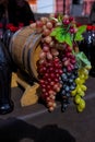 Bunches of white, pink and dark grapes on an old wooden wine barrel. Royalty Free Stock Photo