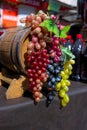 Bunches of white, pink and dark grapes on an old wooden wine barrel. Royalty Free Stock Photo